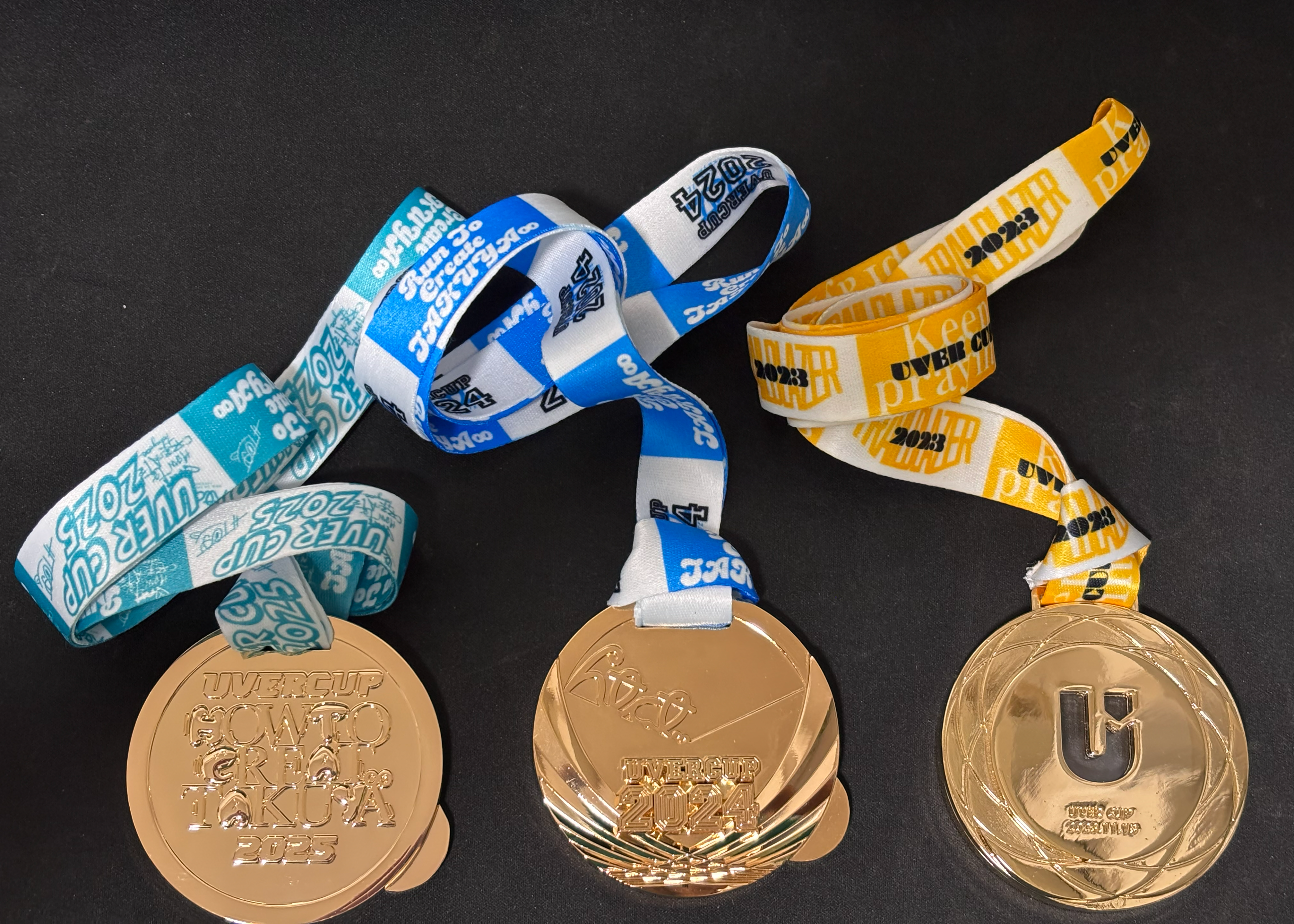 今回のUVERcupで手にしたメダルと過去のメダル(2022,2023のメダル）の画像。